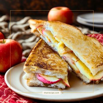 grilled cheese sandwich on a plate with apples in the background