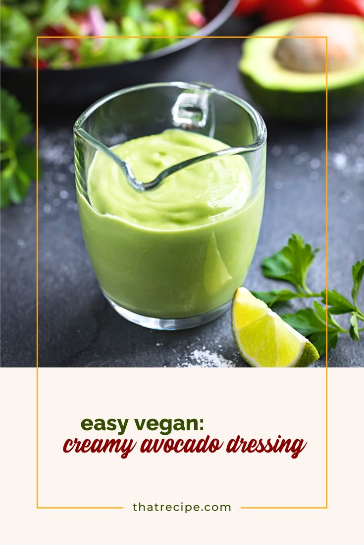 avocado salad dressing in a glass jug on a table with salad