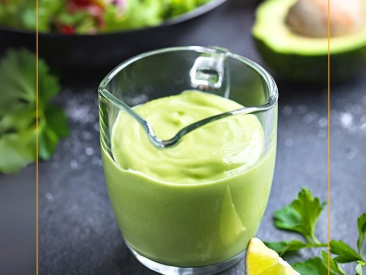 avocado salad dressing in a glass jug on a table with salad