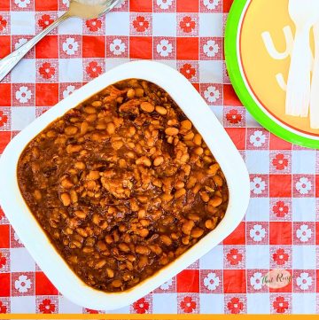 dish of baked beans with text overlay "BBQ Pork and Beans in a pressure cooker"