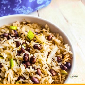 bowl of black beans and rice on white wood background with blue cloth
