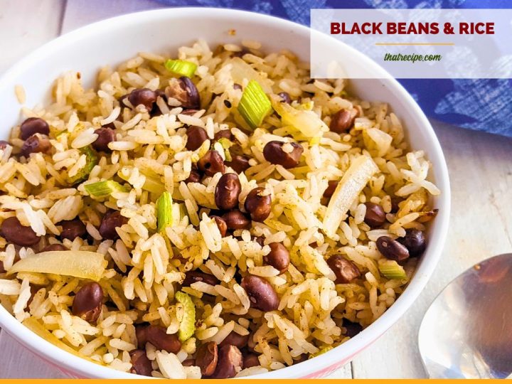 bowl of black beans and rice on white wood background with blue cloth