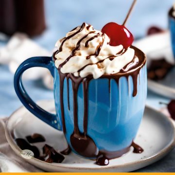 cup of whipped cream covered coffee with cherry on top