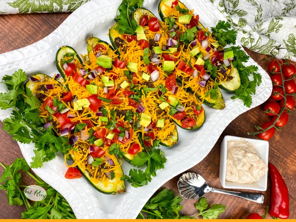 stuffed zucchini with ground beef, cheese, onion, avocado and tomatoes