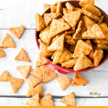 cheese crackers in a bowl and on a table with text overlay "homemade cheese crackers"