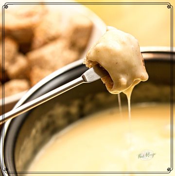 piece of bread dipped in cheese fondue with text overlay "alcohol free cheese fondue"
