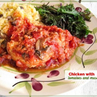 chicken with tomatoes and mushrooms on a plate with polenta and kale