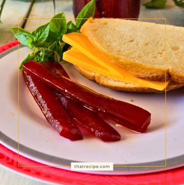 red pickle spears on a plate with a sandwich