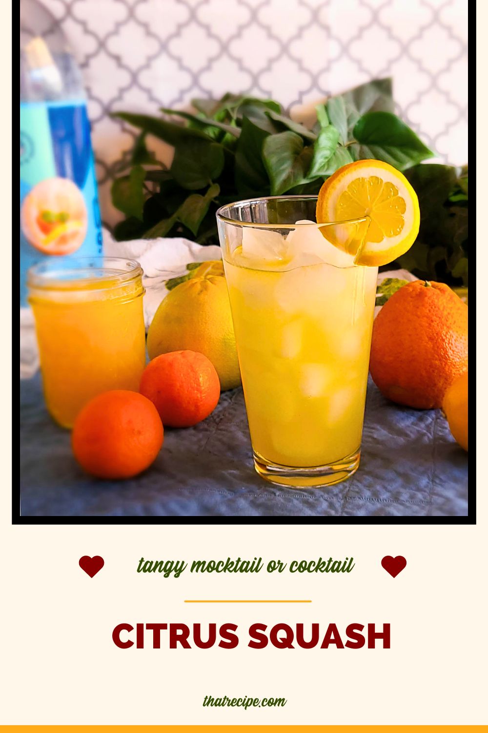 glass of citrus squash on a table surrounded by citrus fruit