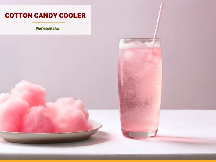 glass of sparkling pink drink with a plate of cotton candy