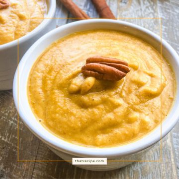 Bowl of pureed soup topped with a pecan