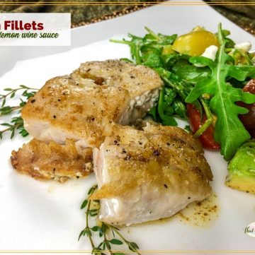 cooked fish fillet on a plate with text overlay "fish fillets with lemon wine sauce"