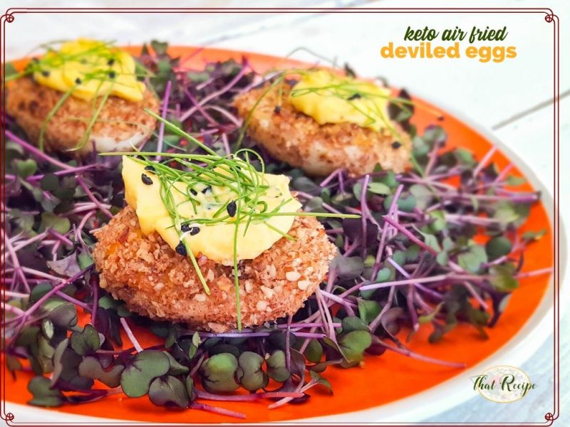 fried deviled eggs on bed of microgreens with text overlay "keto air fried deviled eggs"