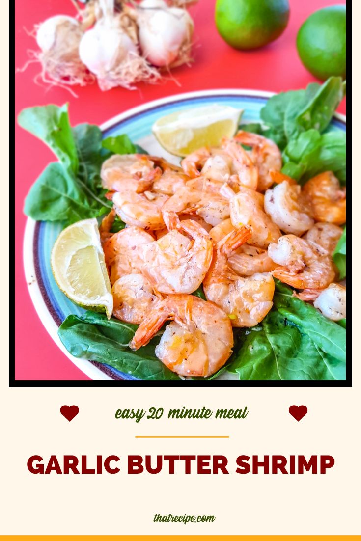 stir fried butter and garlic shrimp with limes and raw garlic in the background with text overlay "garlic butter shrimp"