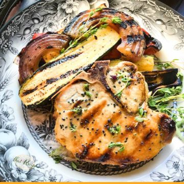 grilled pork chop and vegetables on a plate