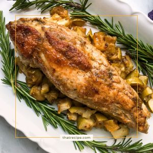 pork tenderloin on a plate with fresh rosemary and roasted apples