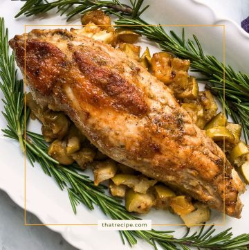 pork tenderloin on a plate with fresh rosemary and roasted apples