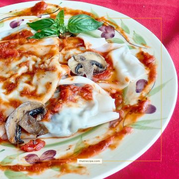 ravioli with red sauce and mushroom slices on a plate
