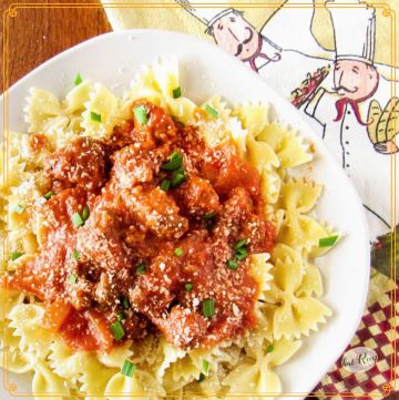Bow tie pasta on a plate covered in sausage pasta sauce
