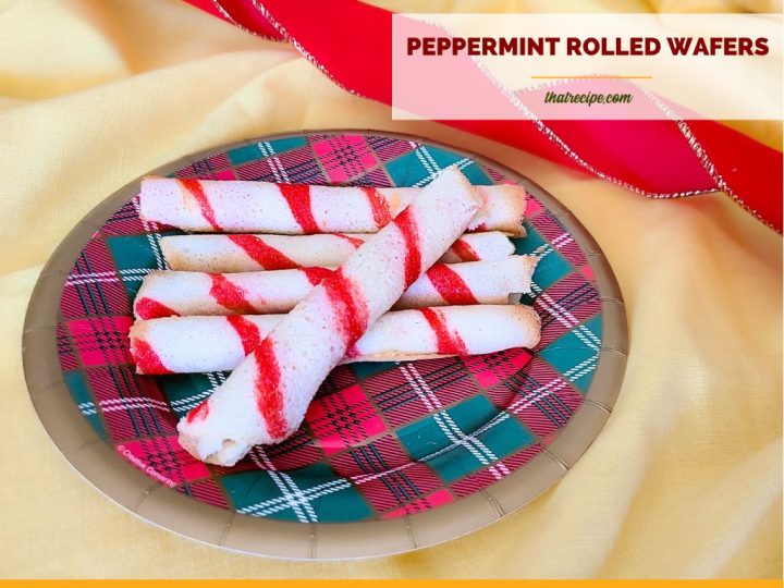 striped cookie rolls on a plate with text "peppermint rolled wafers"