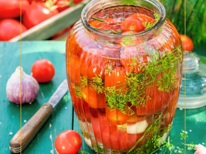 cherry tomatoes in a jar with fresh herbs, garlic and liquid