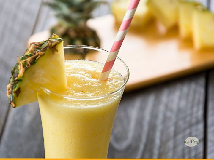 pineapple slushie on a table with fresh pineapple