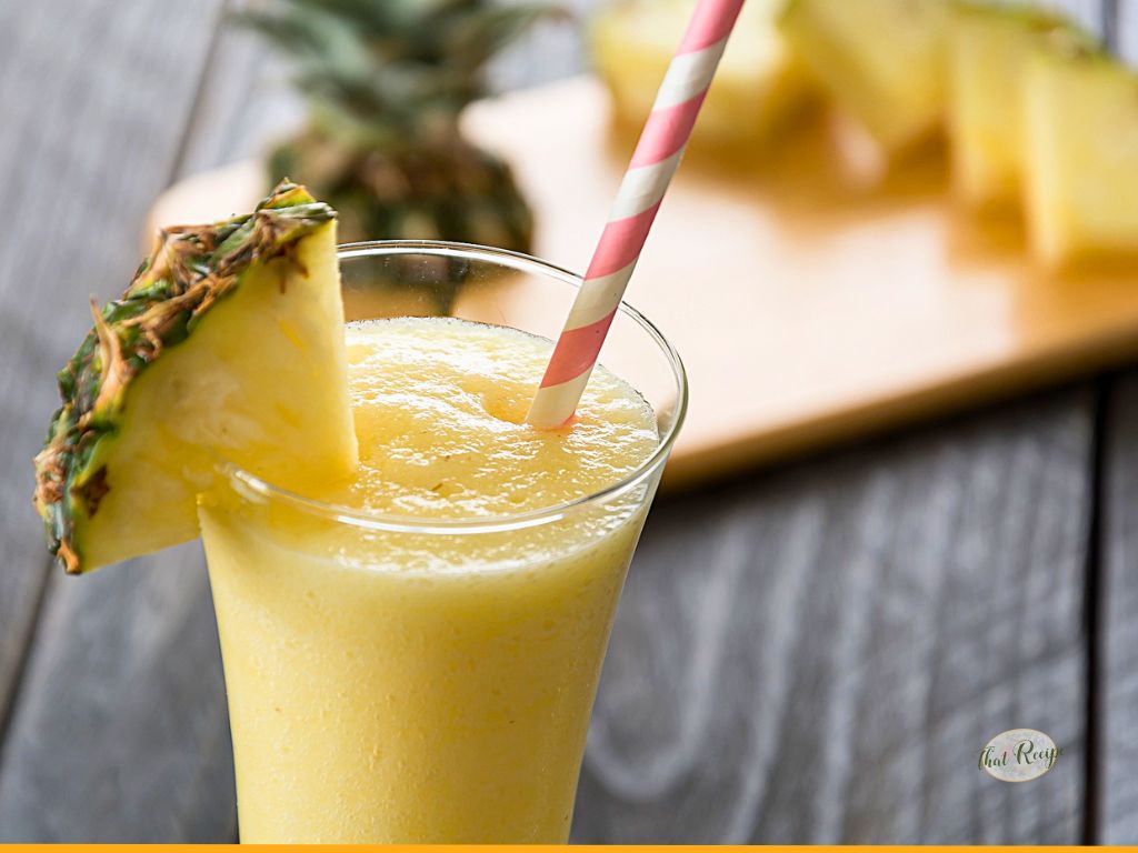pineapple slushie on a table with fresh pineapple