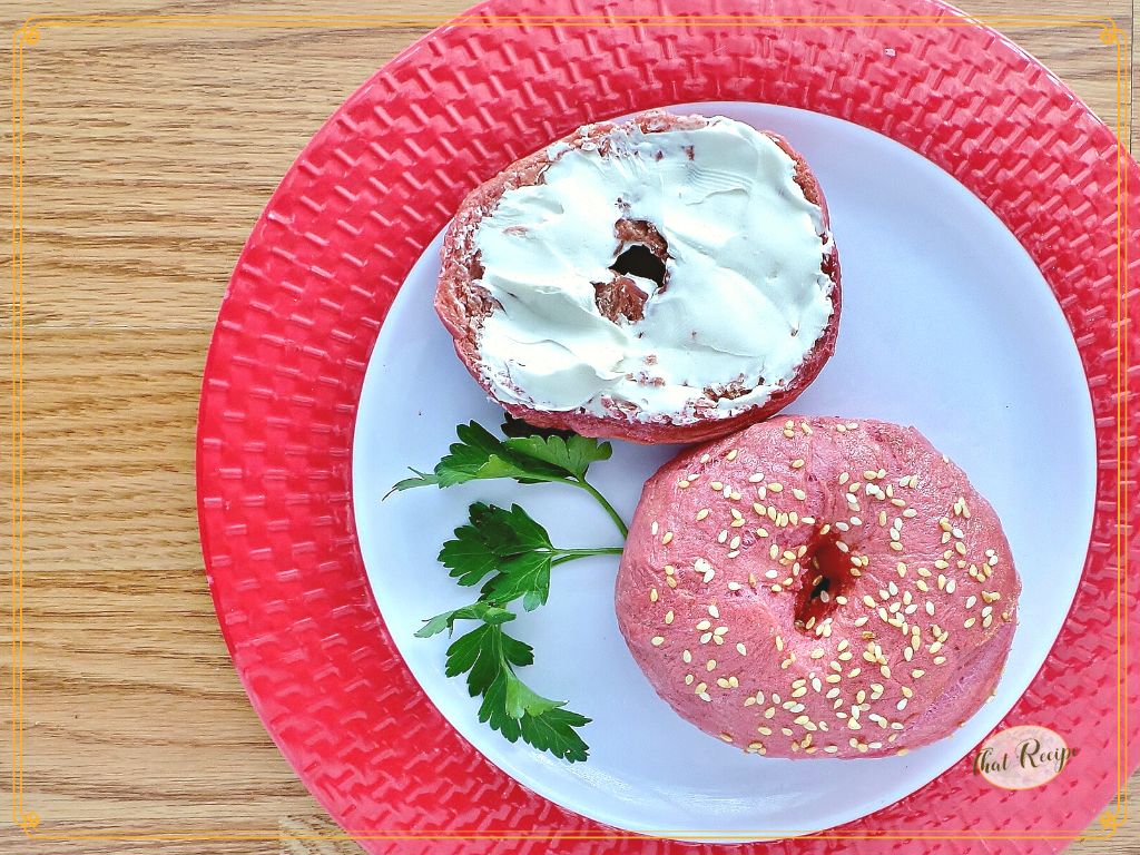 pink bagel on a plate with schmear of cream cheese