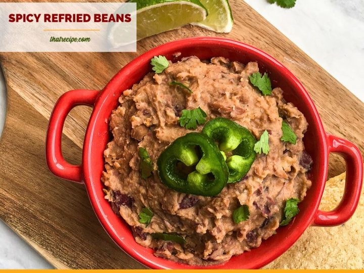 bowl of refried beans on a chopping block with limes
