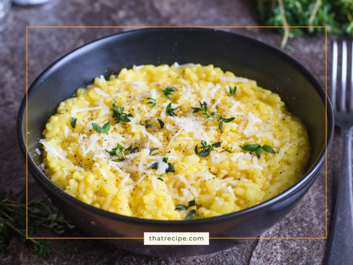 risotto in a bowl topped with Parmesan cheese and herbs