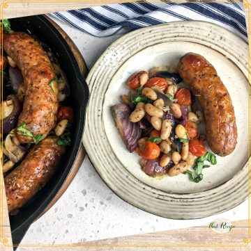 top down view of cast iron skillet meal with text overlay "one oan sausage and white beans"