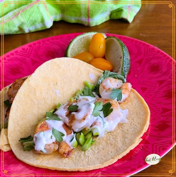 shrimp tacos on a plate with text overlay "weeknight fast shrimp tacos"