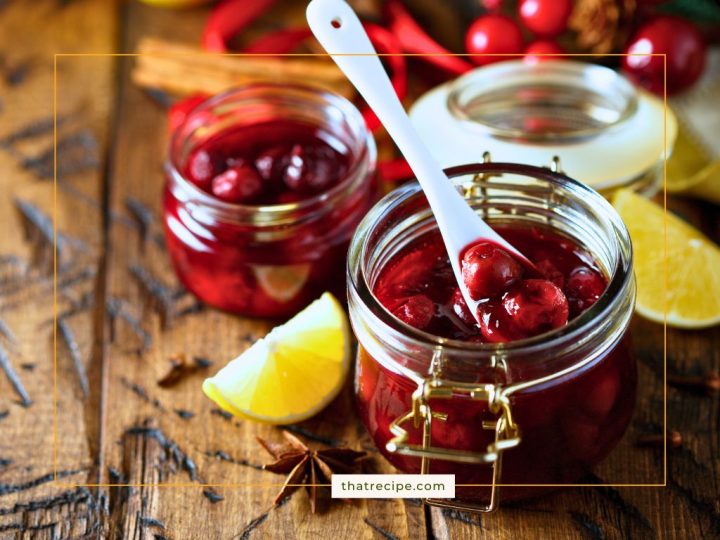 jars of cherry chutney with lemon slices, cherries and cinnamon