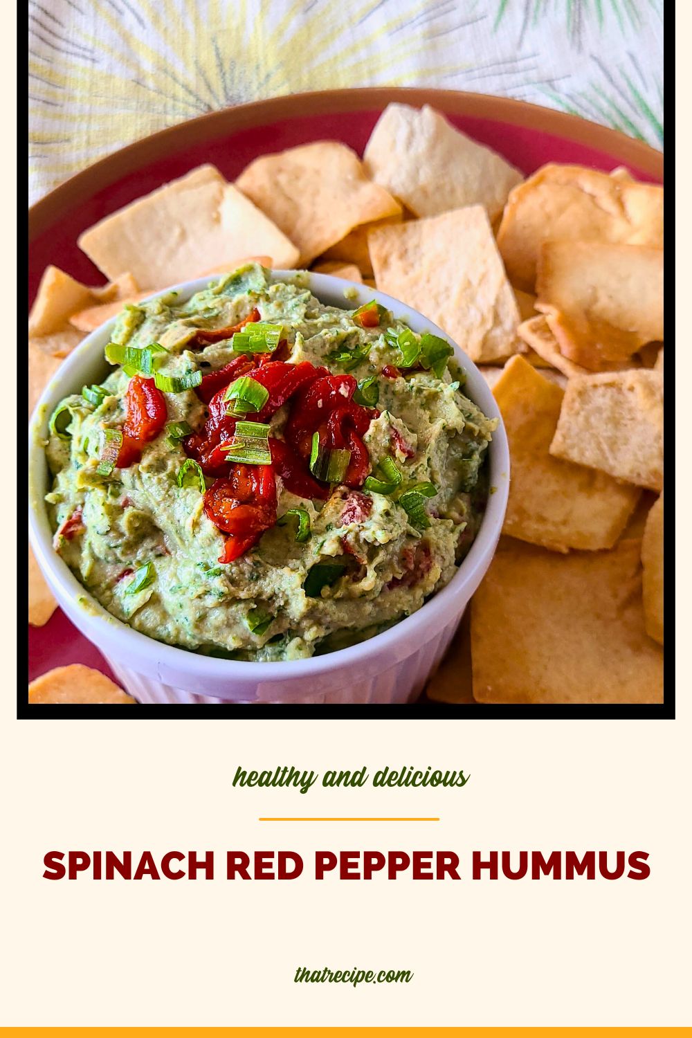 green and red hummus in a bowl with pita chips and text overlay "spinach and red pepper hummus"