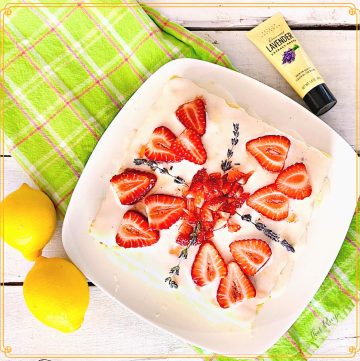 square cake topped with fresh strawberries and fresh lavender blossoms