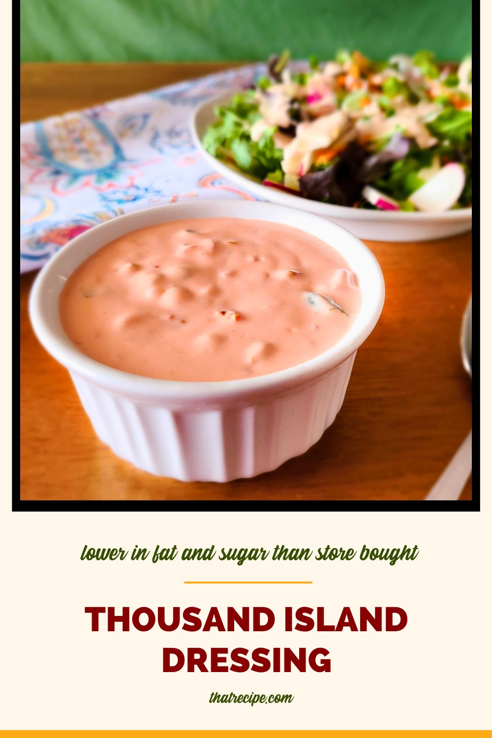 cup of thousand island dressing with a salad in background