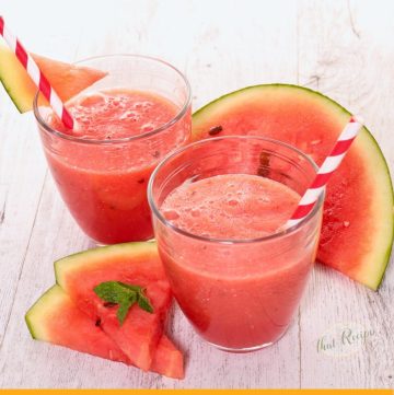 two glasses of watermelon smoothies with watermelon slices with text overlay "watermelon mint smoothie"